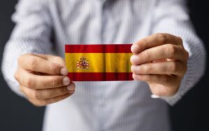 ręce trzymające flagę hiszpanii